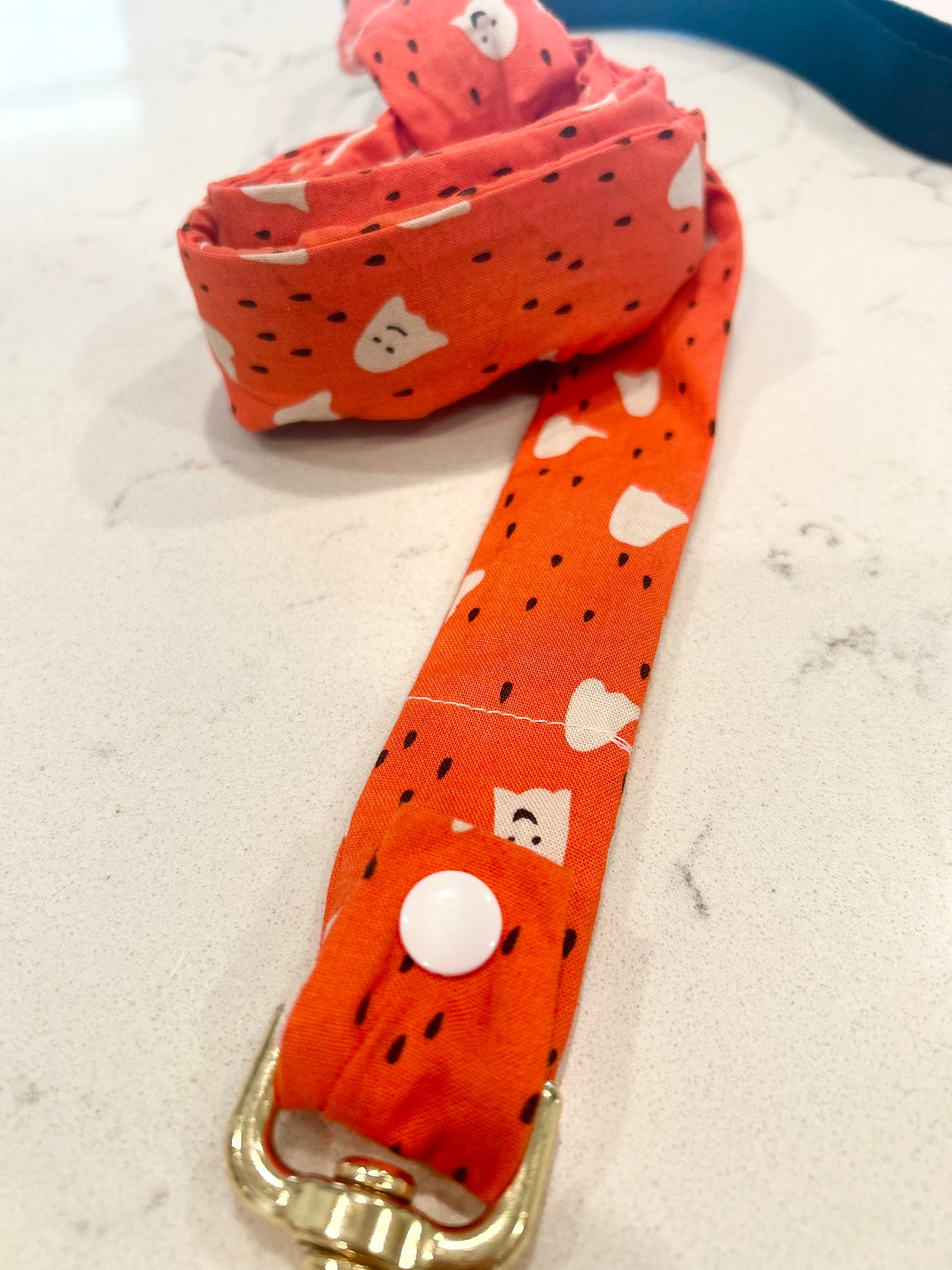 Orange and white ghost leash cover on white surface