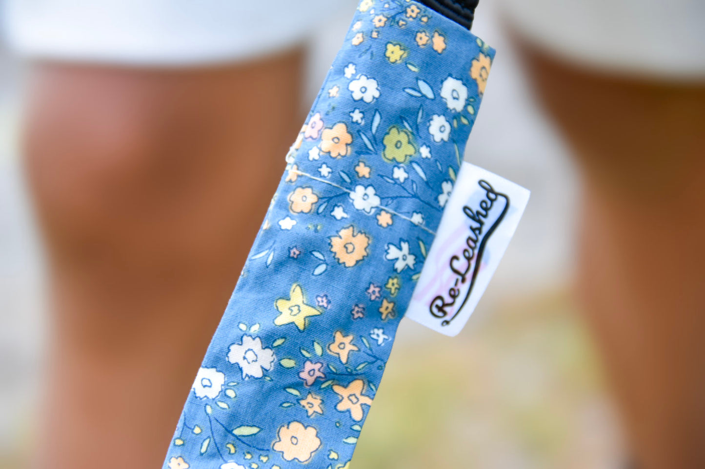 Close up releashed tag on blue floral leash cover
